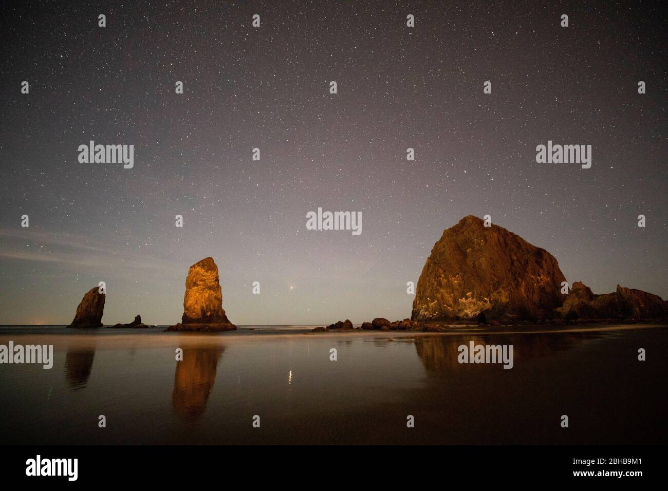 Condimento con oggetti di roccia al crepuscolo, Cannon Beach, Oregon, Stati Uniti Foto Stock