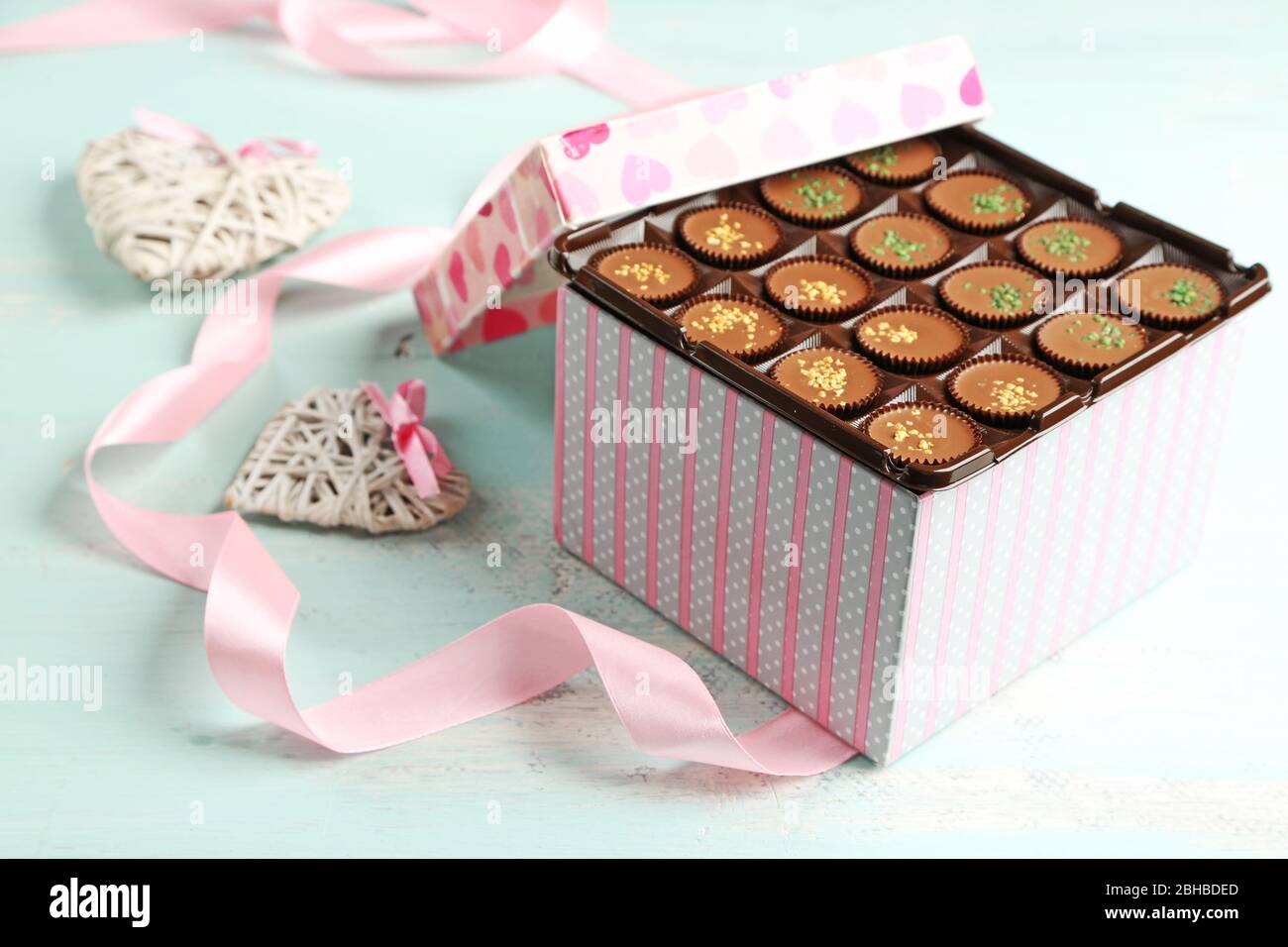 Scatola regalo con gustose caramelle al cioccolato su tavolo in legno Foto Stock