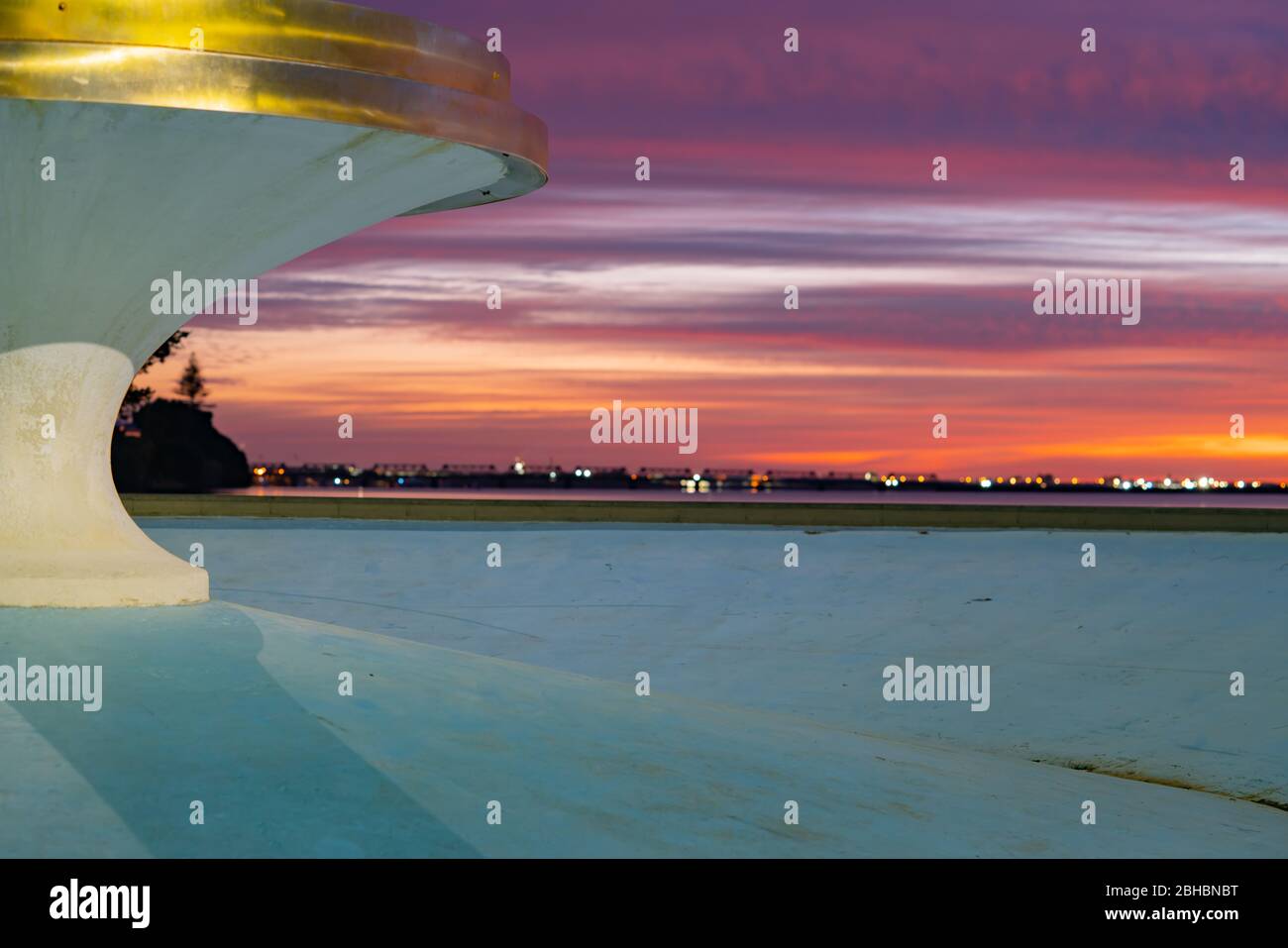 Fontana vuota al Memorial Park sul cielo vibrante all'alba al momento del blocco coviod-19 in Tauranga Nuova Zelanda. Foto Stock