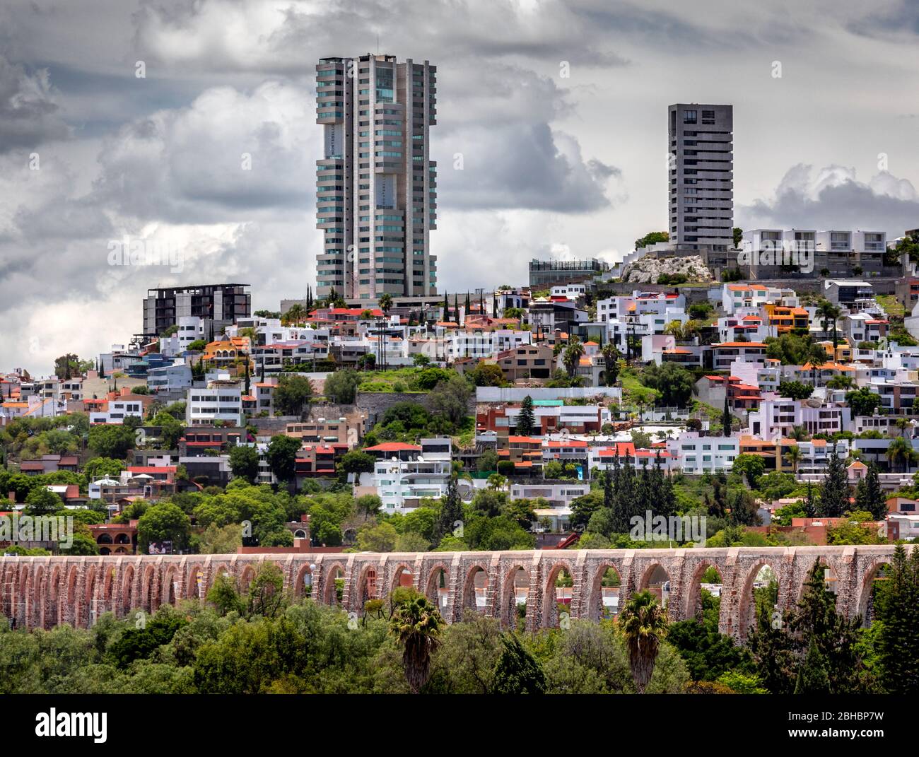 Il vecchio e il nuovo si combinano a Queretaro, Messico, come alti edifici di appartamenti salgono vicino all'acquedotto coloniale. Foto Stock