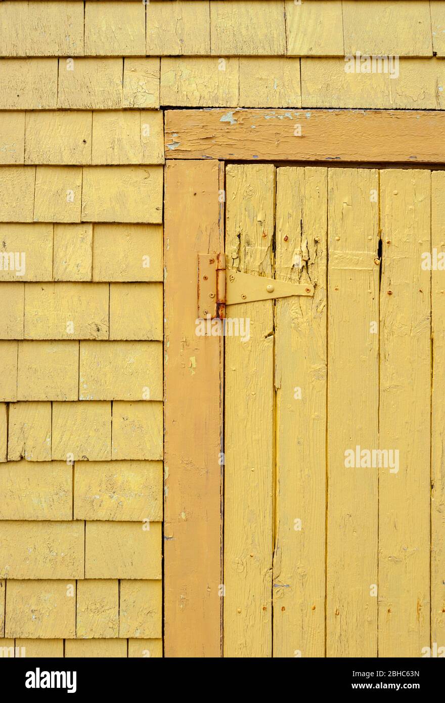 Negozio di articoli da regalo Seagull's Nest. Dettagli in façade verniciati in giallo. Cerniera per porta che supporta una tavola e una porta battente. Legno-conchioni di legno. Nord rustico Porto PEI Foto Stock