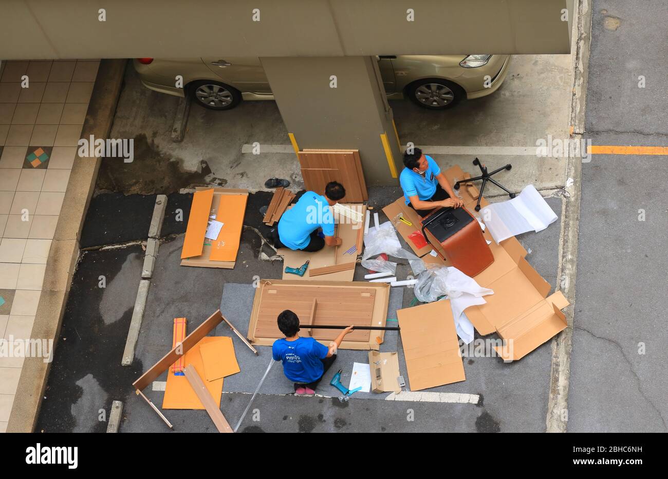 Bangkok Thailandia - Aprile 25 2020: Un team di tre lavoratori sta assemblando mobili abbattere sul parcheggio prima di consegnare al cliente, Foto Stock