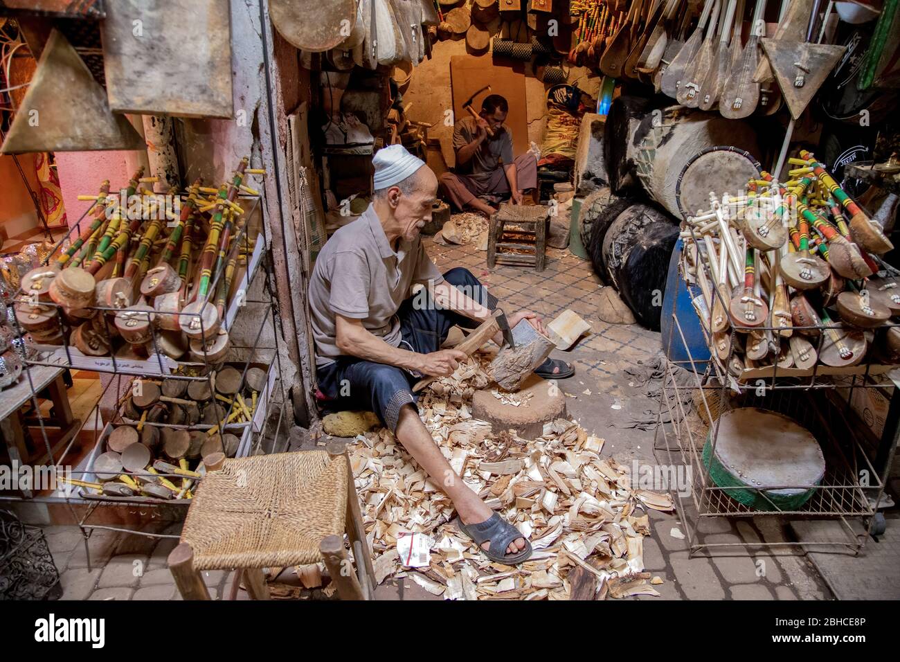 Uomo che intaglia uno strumento tradizionale marocchino di legno al Bazaar Medina di Marrakesh, Marocco. Foto Stock