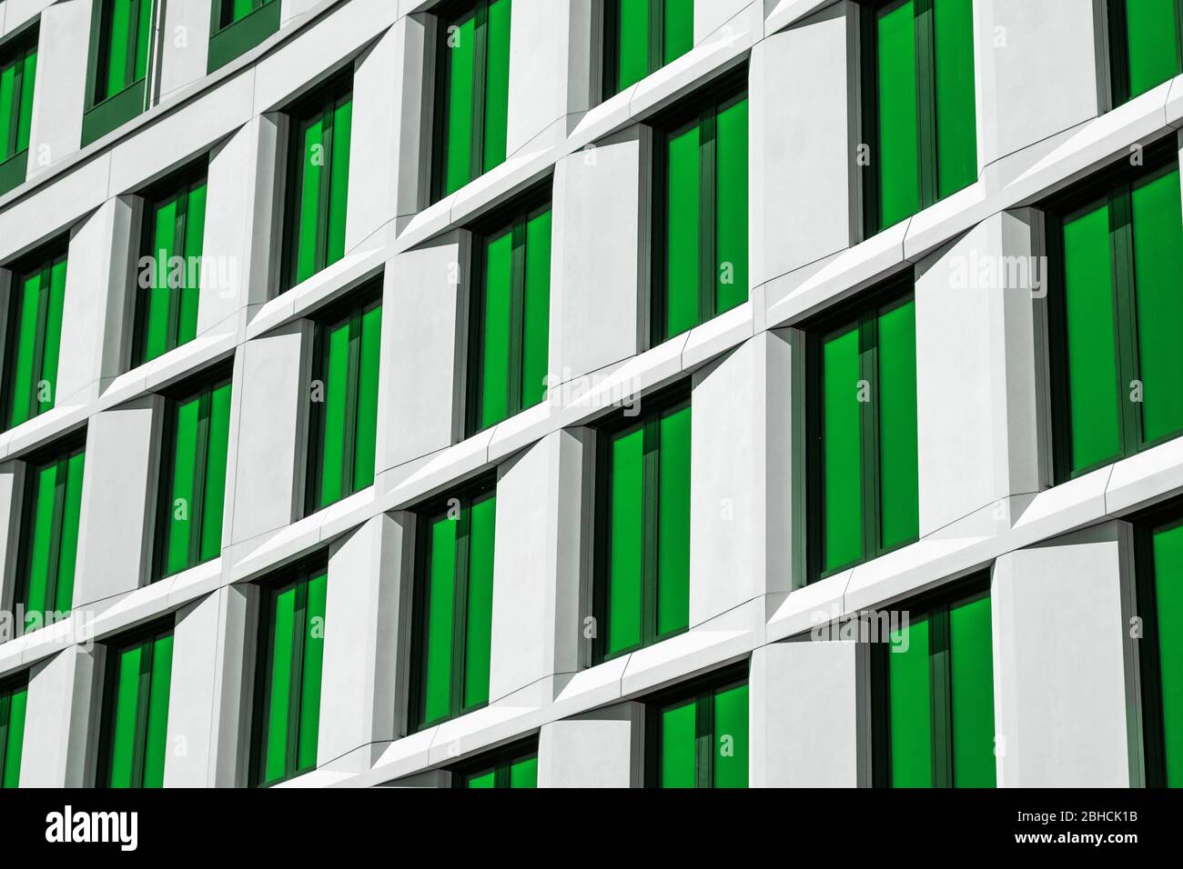 edificio moderno con facciata, finestre dalle sfumature verdi Foto Stock