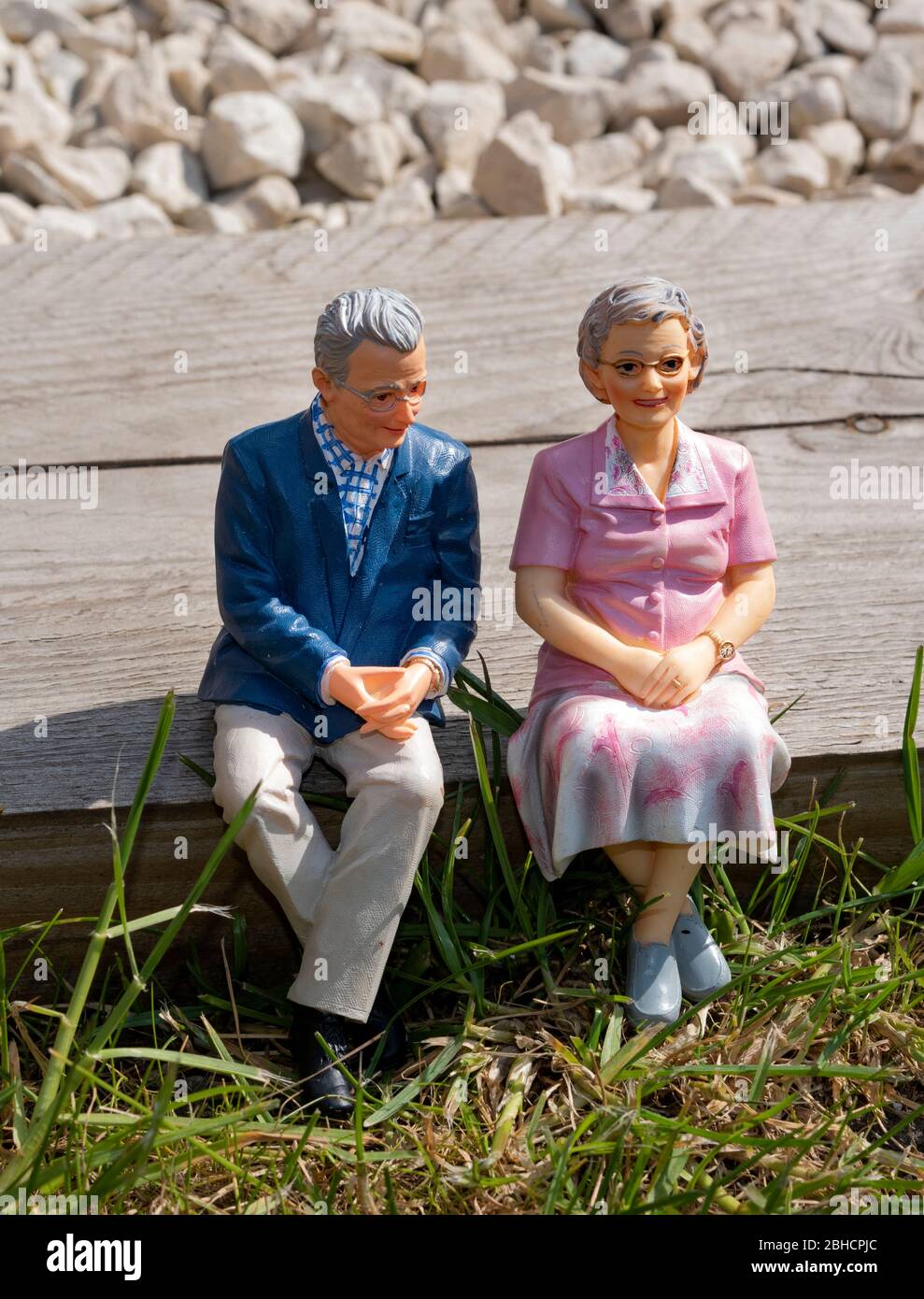 Figurina in miniatura, coppia pensionato, seduta all'aperto in un giardino, concetto di pensionamento Foto Stock