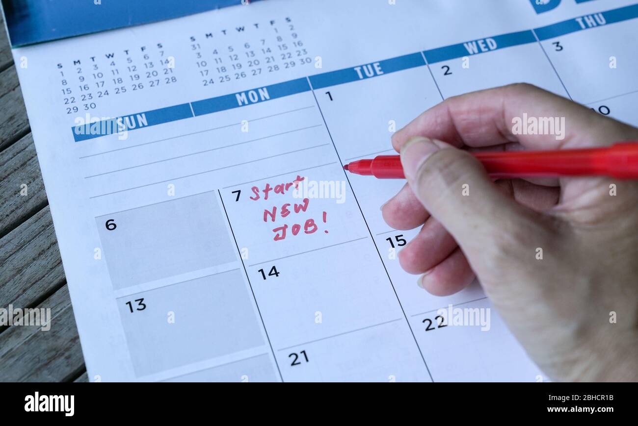 Avviare nuove parole di lavoro scritte sul calendario della tabella con un indicatore rosso. Concetto di occupazione o di carriera. Foto Stock