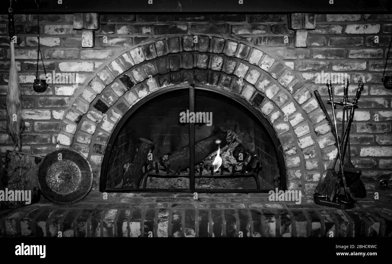 Camino in pietra bianco e nero con fuoco incandescente. Camino in stile vintage Foto Stock