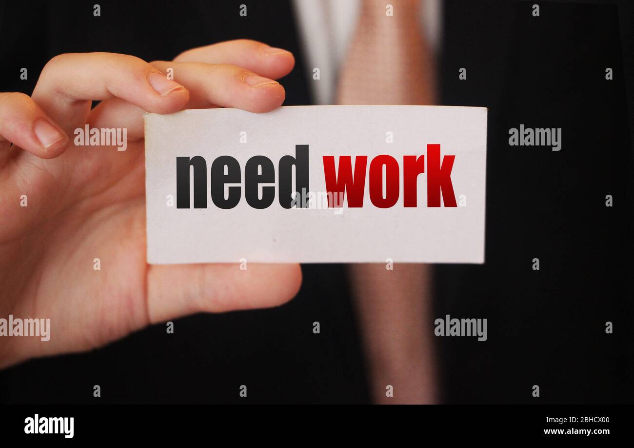 Testo di lavoro di bisogno su carta businessman tiene. Concetto di crisi globale della forza lavoro qualificata e disoccupata Foto Stock