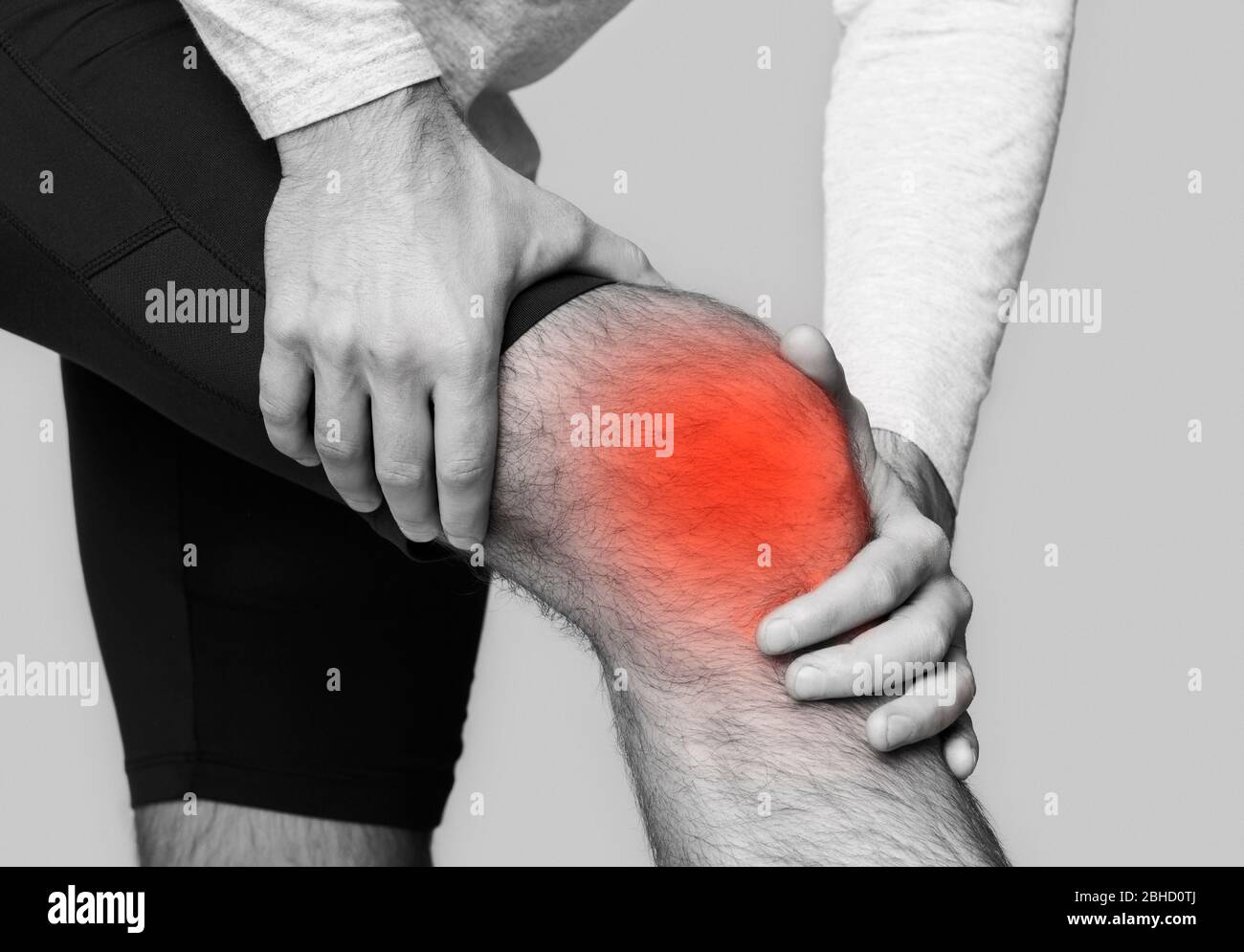 Uomo con dolore al ginocchio, evidenziato in rosso Foto Stock