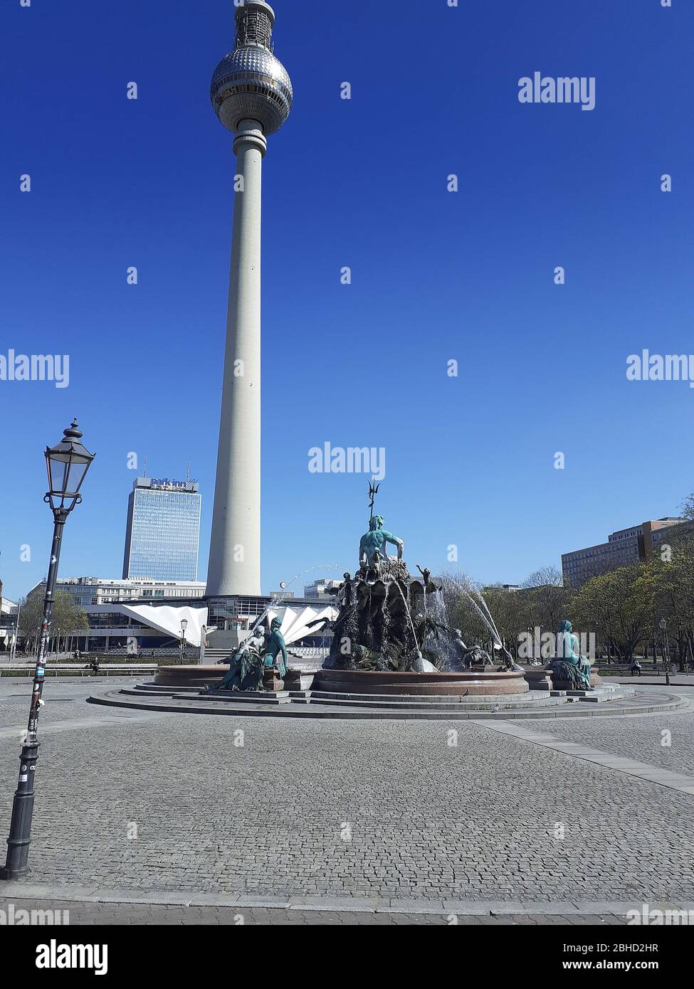 La Fontana di Nettuno con il Fernsehturm sullo sfondo, privo di turisti durante la chiusura a causa della pandemia di Coronavirus, 2020 aprile, Berlino, Germania Foto Stock