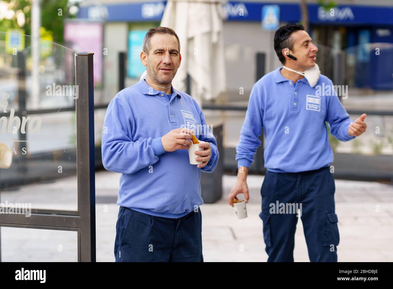 GRANADA, SPAGNA, 23 APRILE 2020 lavoratori che mangiano cioccolata calda e churros in pausa, indossando maschere Foto Stock