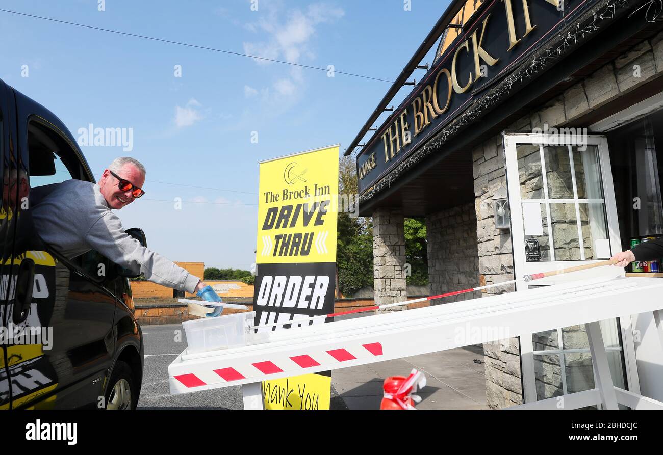 John Edward raccoglie il suo cambiamento dalla cassa a pagamento al Brock Inn, Co. Dublin, dove hanno allestito un 'Contactless Drive Thru Service' che serve colazione, pranzo e cena. Foto Stock