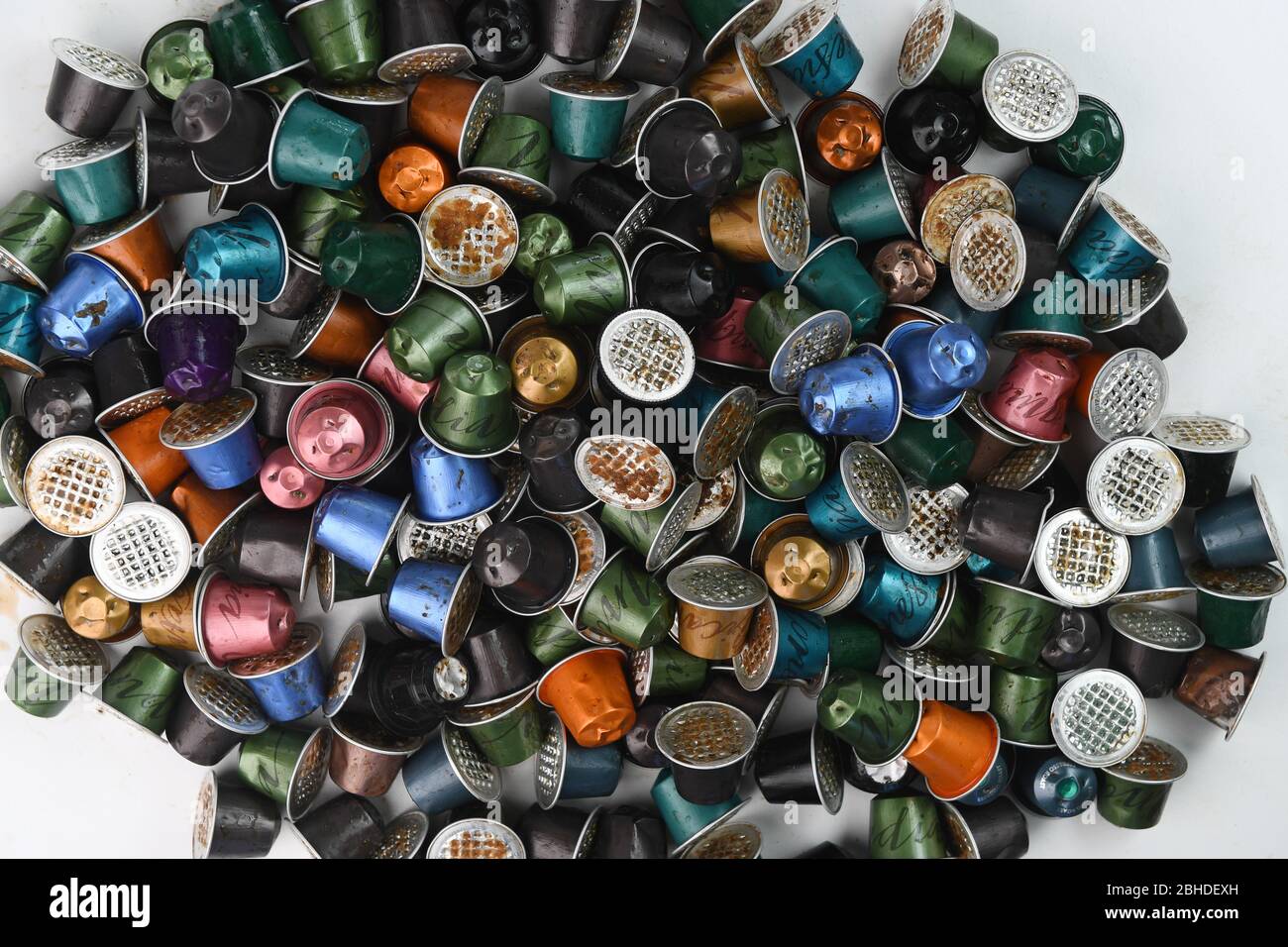 Una pila di capsule di caffè Nespresso usate su sfondo bianco pronte per il riciclaggio. Foto Stock
