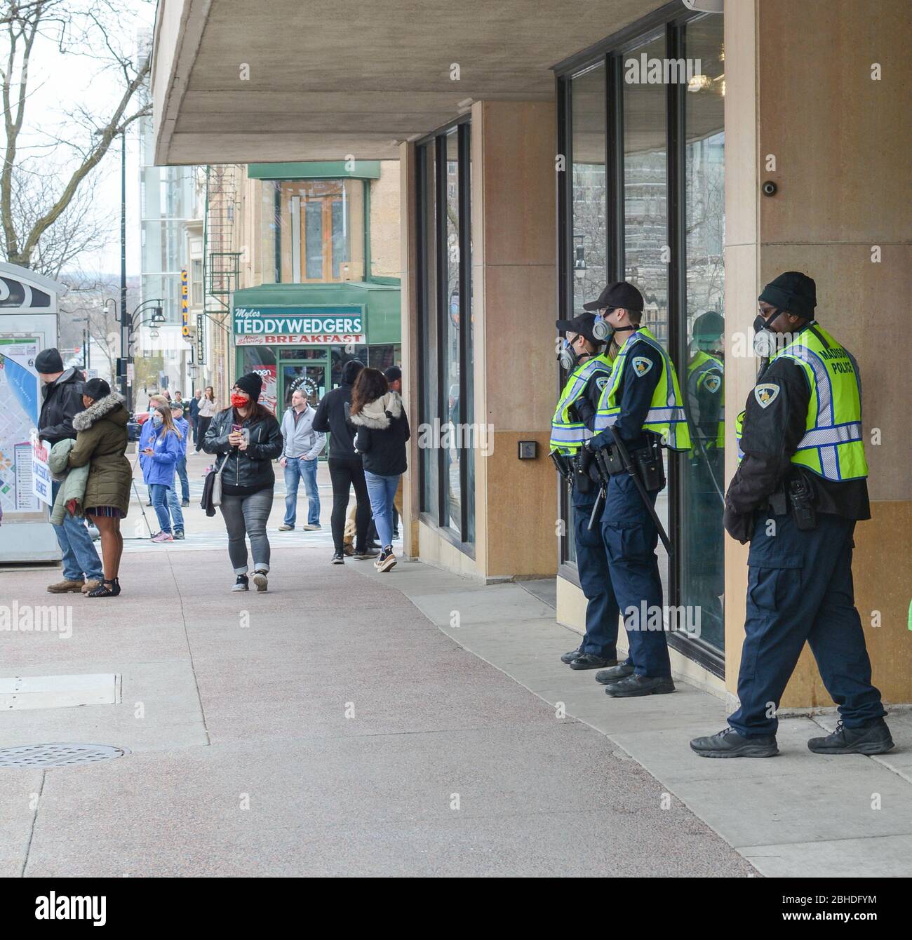 Polizia in piedi pronti ad un rally nel Madison WI USA. Protestando per l'ordine di soggiorno prolungato da Gov Evers dovuto il coronavirus Foto Stock