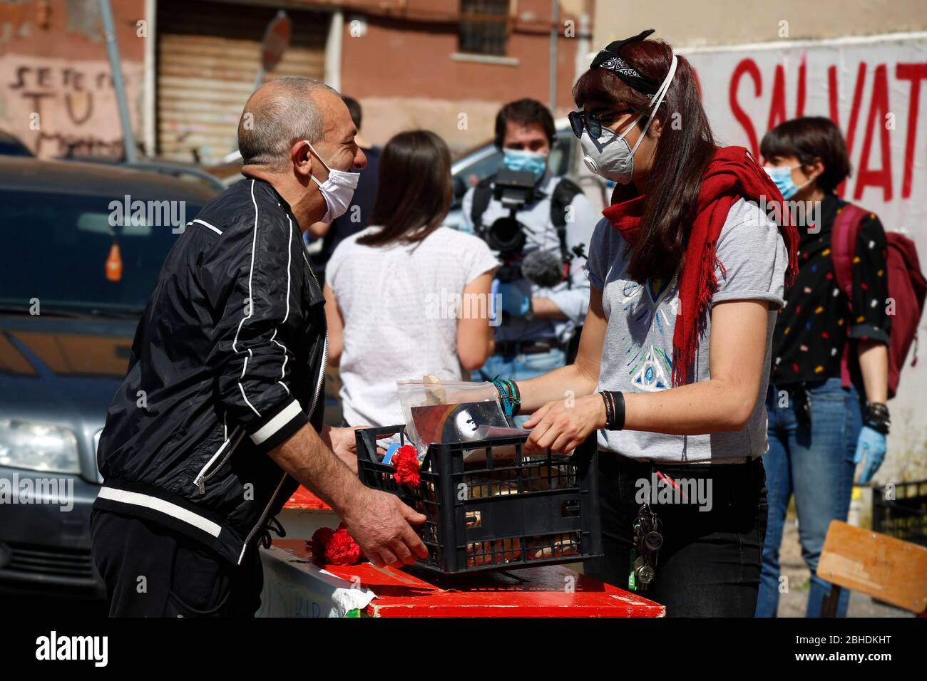 Roma, Italia. 25 Aprile 2020. Roma 25 Aprile 2020. Blocco del coronavirus. In tutta Italia il blocco dei Coronavirus ha migliorato la crisi economica, così in molti quartieri associazioni e volontari distribuire cibo a persone meno abbienti. Nel distretto di Quarticciolo il 25 aprile (anniversario della liberazione dell'Italia dal fascismo nazista e anniversario della resistenza), i volontari del Red Lab distribuiscono insieme cibo, garofano rosso e foto. Foto Samantha Zucchi Insidefoto Credit: Insidefoto srl/Alamy Live News Foto Stock