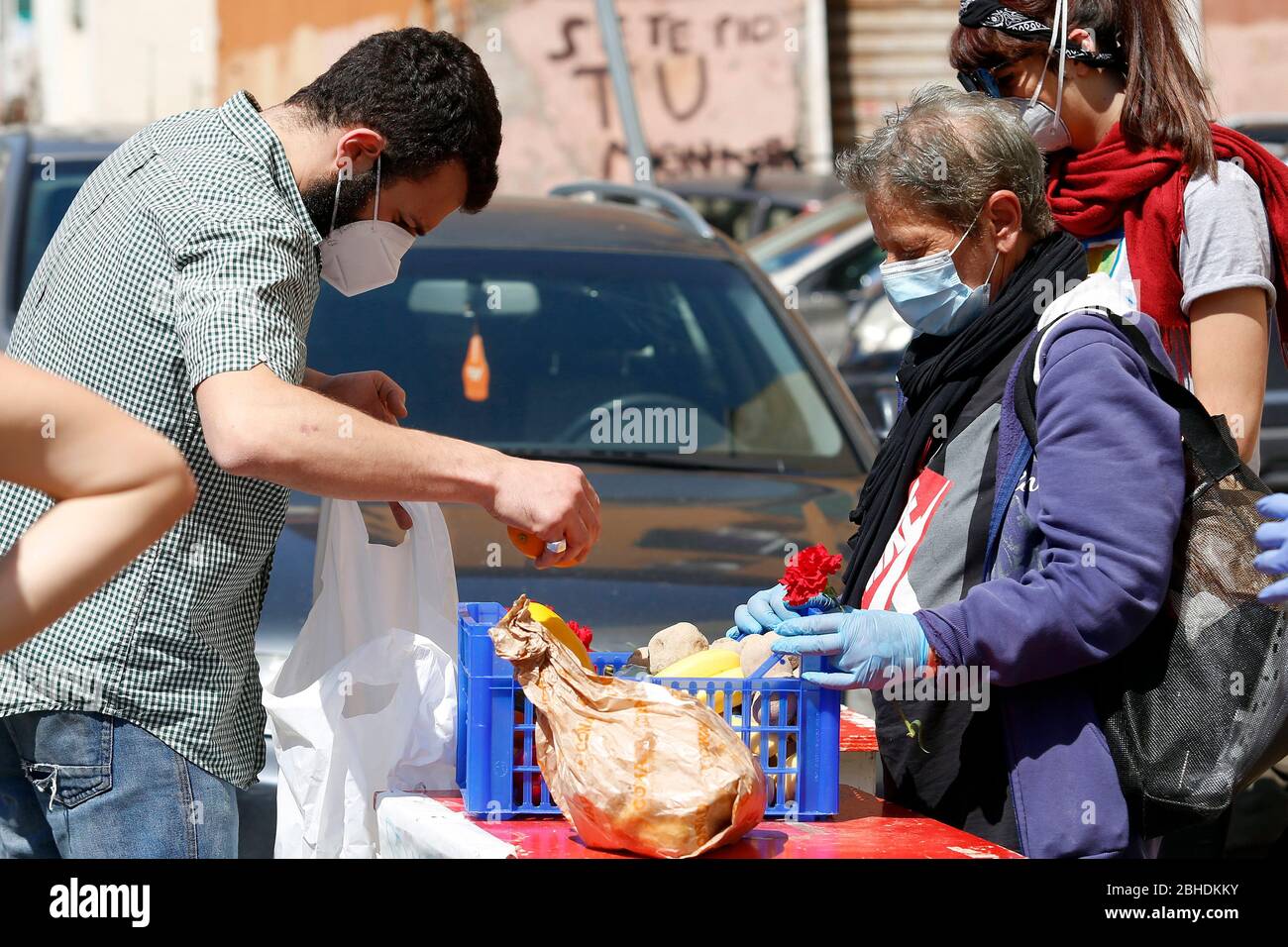 Roma, Italia. 25 Aprile 2020. Roma 25 Aprile 2020. Blocco del coronavirus. In tutta Italia il blocco dei Coronavirus ha migliorato la crisi economica, così in molti quartieri associazioni e volontari distribuire cibo a persone meno abbienti. Nel distretto di Quarticciolo il 25 aprile (anniversario della liberazione dell'Italia dal fascismo nazista e anniversario della resistenza), i volontari del Red Lab distribuiscono insieme cibo, garofano rosso e foto. Foto Samantha Zucchi Insidefoto Credit: Insidefoto srl/Alamy Live News Foto Stock