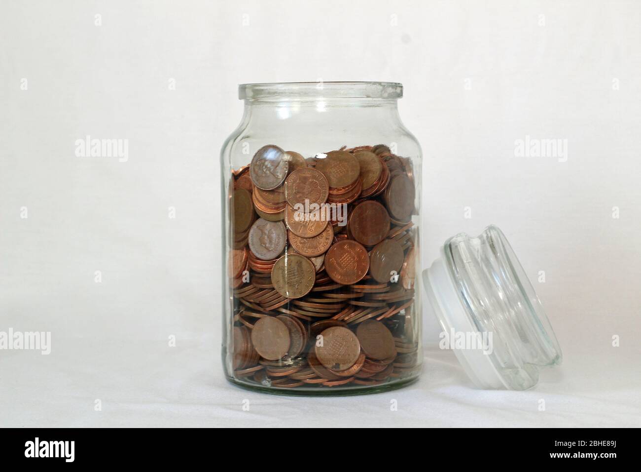 Vasetto di risparmio in vetro con raccolta di monete o risparmio per una giornata piovosa Foto Stock