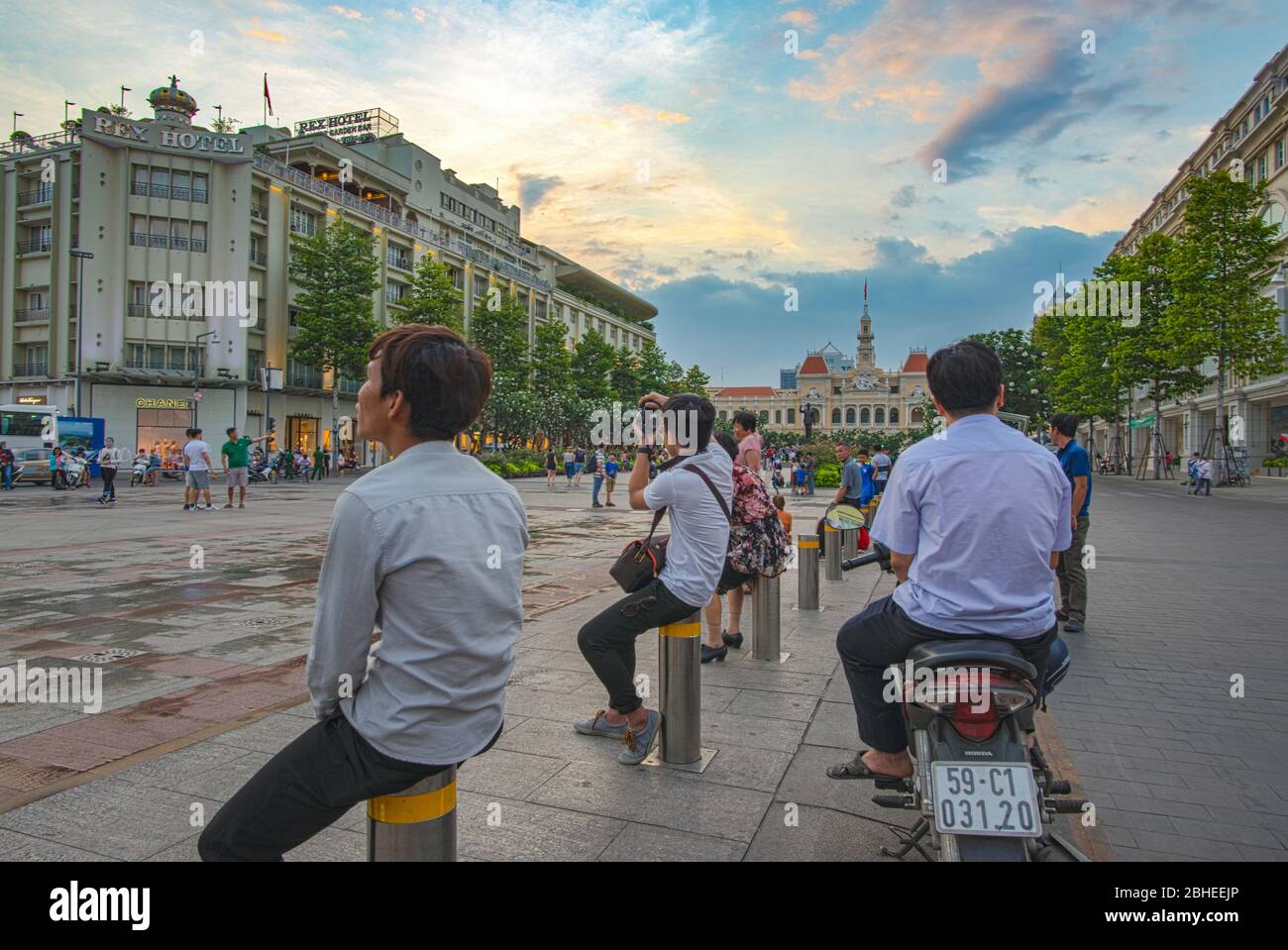 Ho Chi Minh City, Vietnam - 8 aprile 2018: Alcuni abitanti del posto, per lo più uomini, si godono le luci di fine giornata sulla strada pedonale di Nguyen Hue Foto Stock