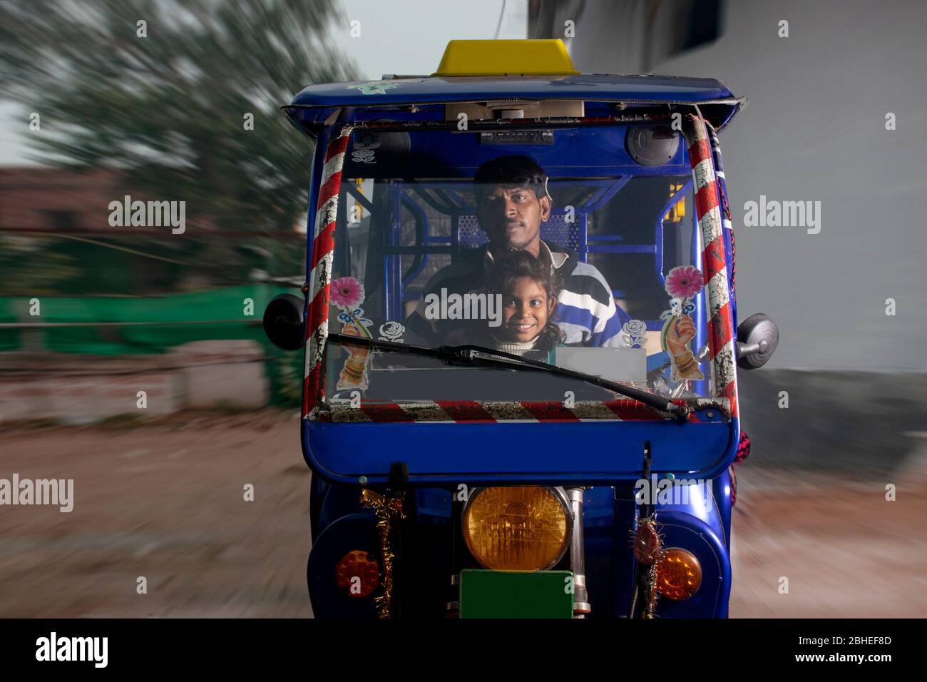 Padre indiano che guida veicolo con il suo bambino, India Foto Stock