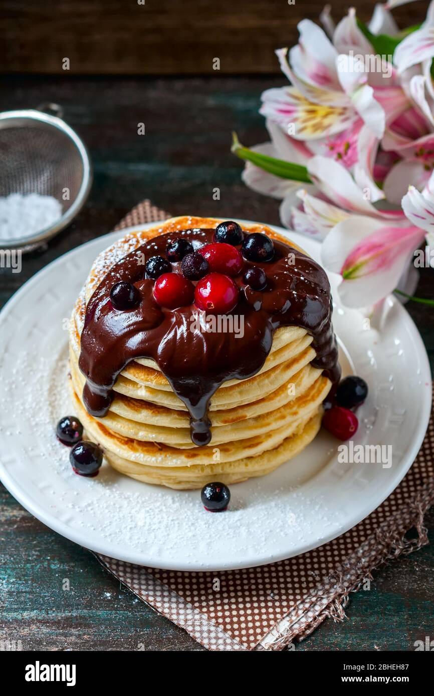 Pancake con frutti di bosco e salsa al cioccolato, fuoco selettivo Foto Stock