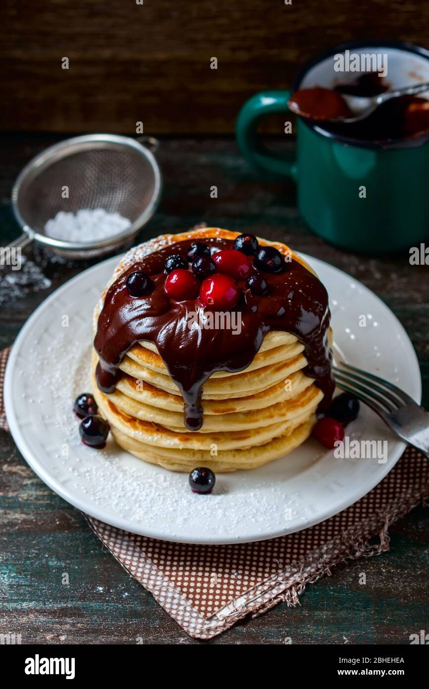 Pancake con frutti di bosco e salsa al cioccolato, fuoco selettivo Foto Stock