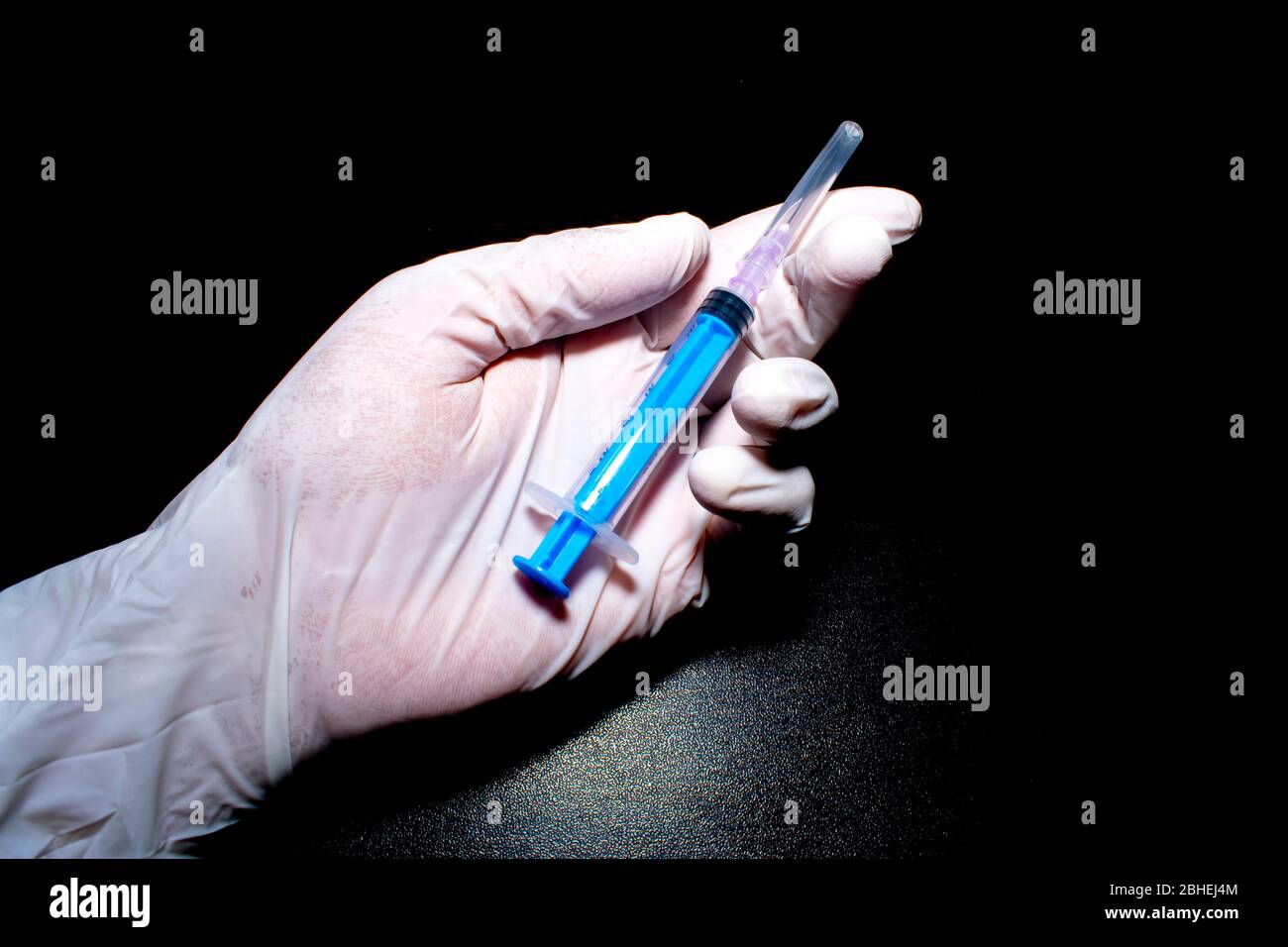 siringa in mano con guanti Foto Stock