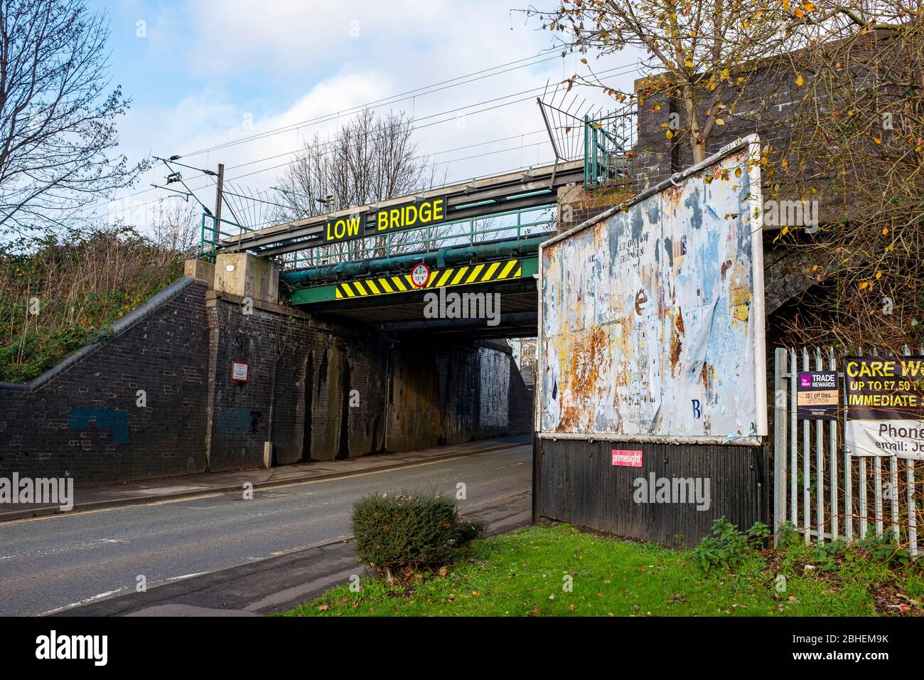 Cartello segnaletico low bridge con affissioni intemperate in Crewe Cheshire UK Foto Stock