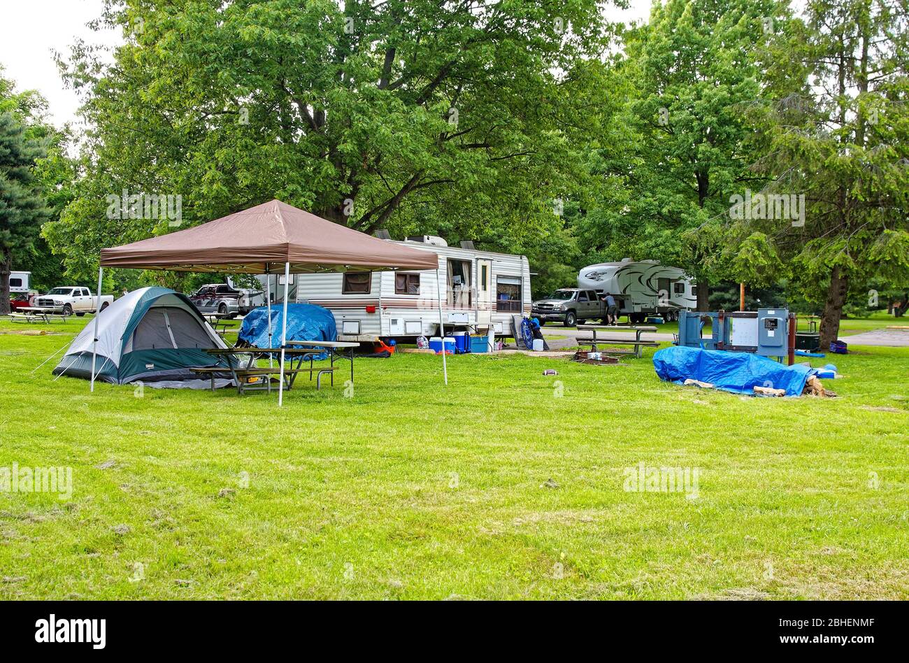 Campeggio scena, rimorchi di viaggio, tenda, coperture blu tarp, camion,  erba, alberi, tettoia sopra tavolo da picnic, vacanza, divertimento, relax,  Kentucky Horse P Foto stock - Alamy