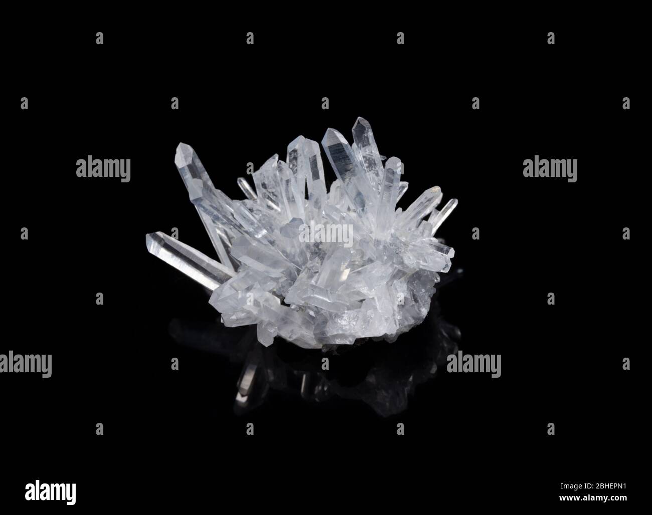 macro shot di un campione di quarzo grezzo a cristalli trasparenti su sfondo nero riflettente Foto Stock
