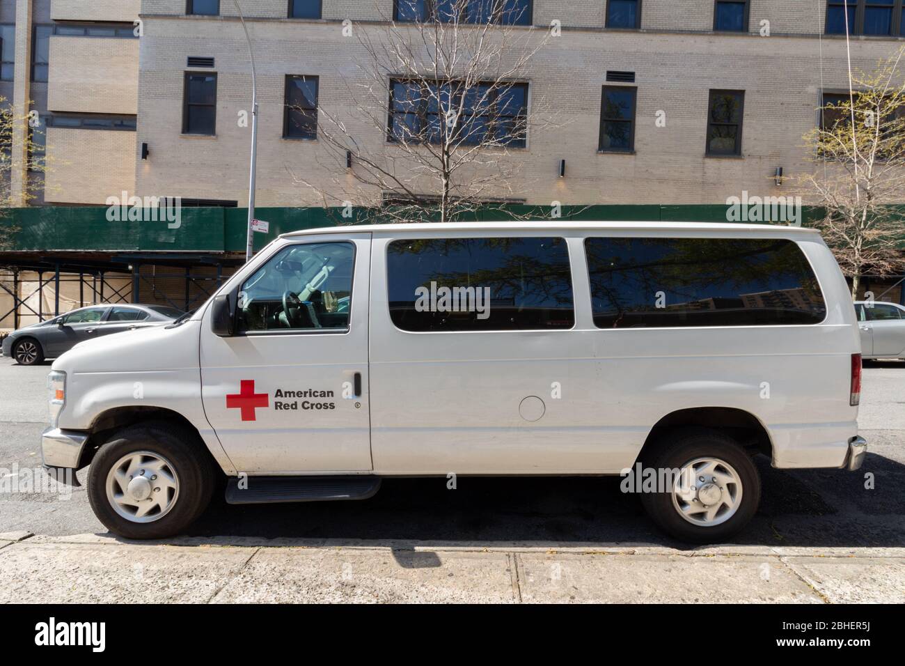 Van appartenente alla Croce Rossa americana parcheggiato su un marciapiede a Inwood, Manhattan. Si tratta di un'organizzazione umanitaria che fornisce aiuti alle catastrofi Foto Stock