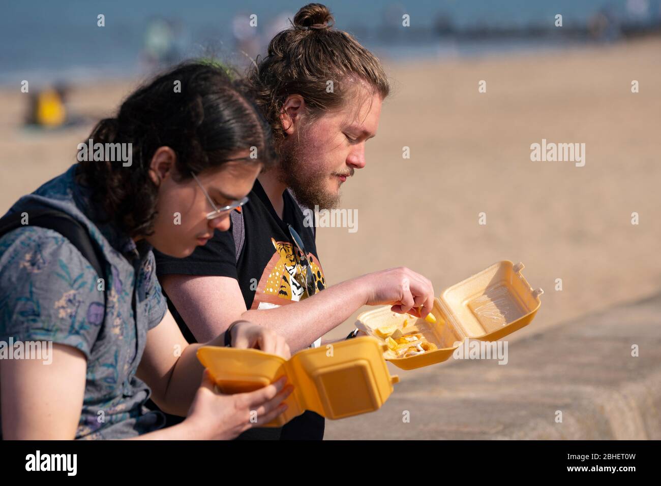 Portobello, Scozia, Regno Unito. 25 aprile 2020. Vista della gente all'aperto il sabato pomeriggio sulla spiaggia e sul lungomare di Portobello, Edimburgo. Il bel tempo ha portato più persone all'aperto a piedi e in bicicletta. La spiaggia sembra occupata con possibile un guasto nelle distanze sociali che accadono più tardi nel pomeriggio. La gente mangia patatine sul lungomare, una bancarella di cibo da asporto è aperta. Iain Masterton/Alamy Live News Foto Stock