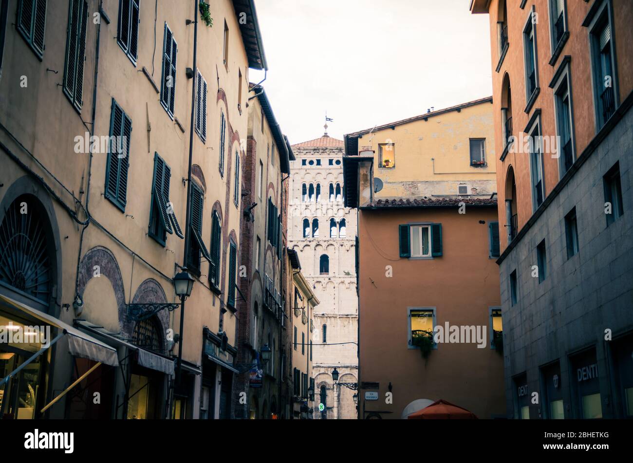 Lucca, Italia, 14 settembre 2018: Campanile della Chiesa di San Michele in Foro Chiesa cattolica vista attraverso la stretta strada nel centro storico della città medievale, vista serale, Toscana Foto Stock