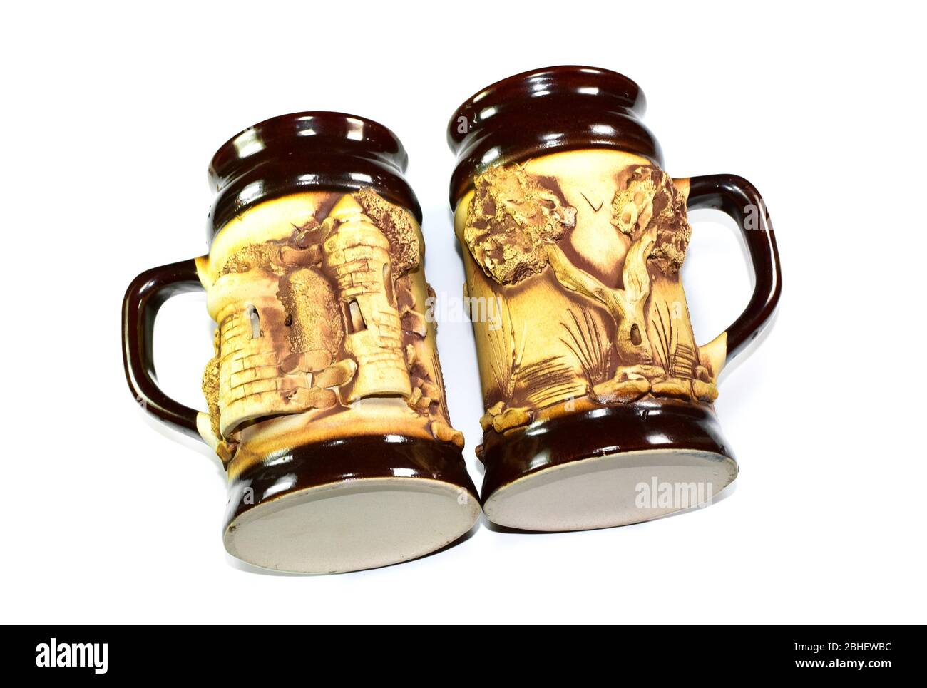 Una tazza di birra con un brelief, un albero e una casa vicino allo stagno. Foto Stock