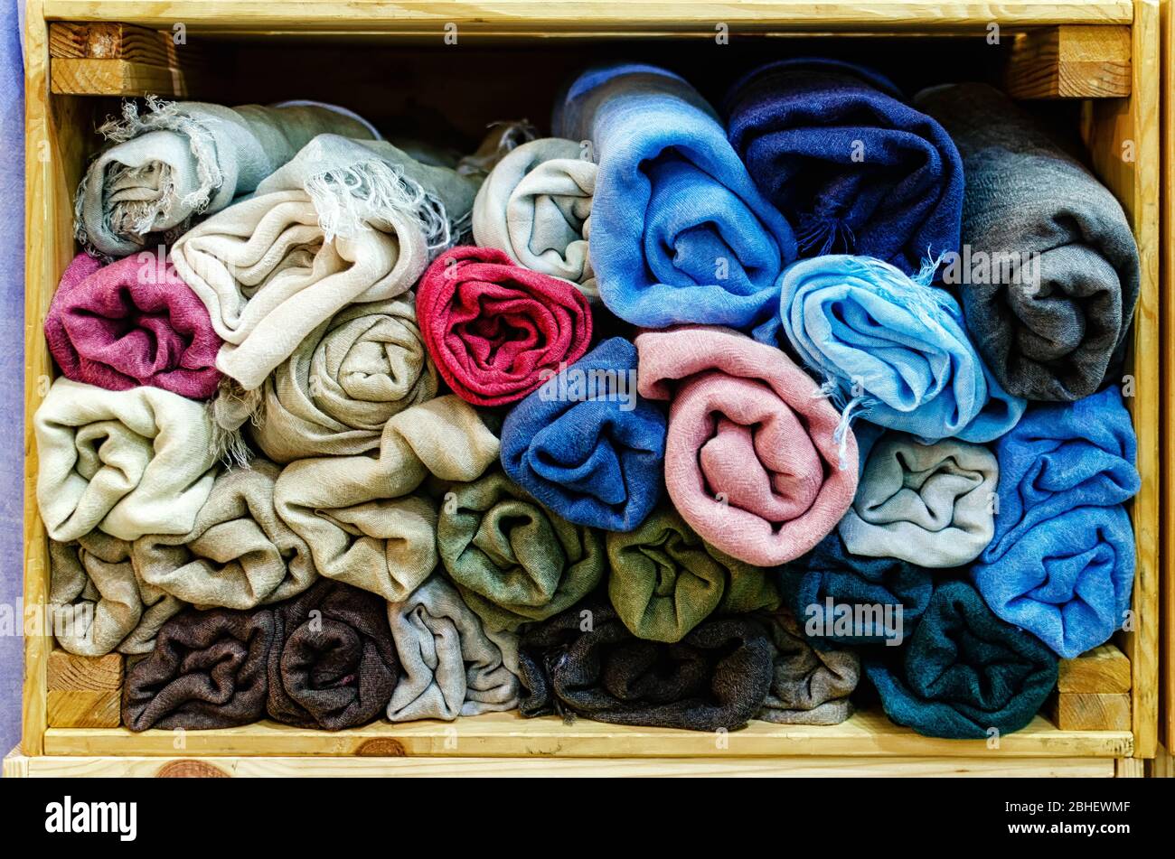 molti foulard di pashmina arrotolati in casse di legno di un mercato stalla Foto Stock