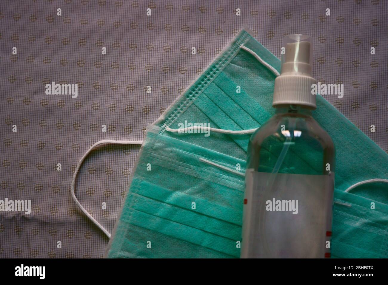 Immagine di maschere e igienizzatore in un flacone trasparente Foto Stock