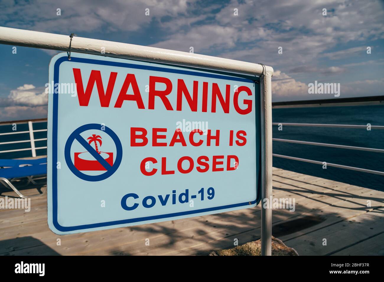 La spiaggia è chiusa a causa del cartello di avvertimento Covid-19 situato all'ingresso di una spiaggia. Campagna sui social media per la prevenzione del coronavirus. L'estate è annullata Foto Stock