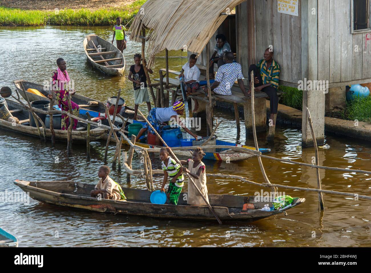 Ganvie villaggio scena con la gente che ottiene acqua potabile per le loro case da un approvvigionamento di acqua pulita. E' un villaggio unico costruito su palafitte, sul Lago NOK Foto Stock