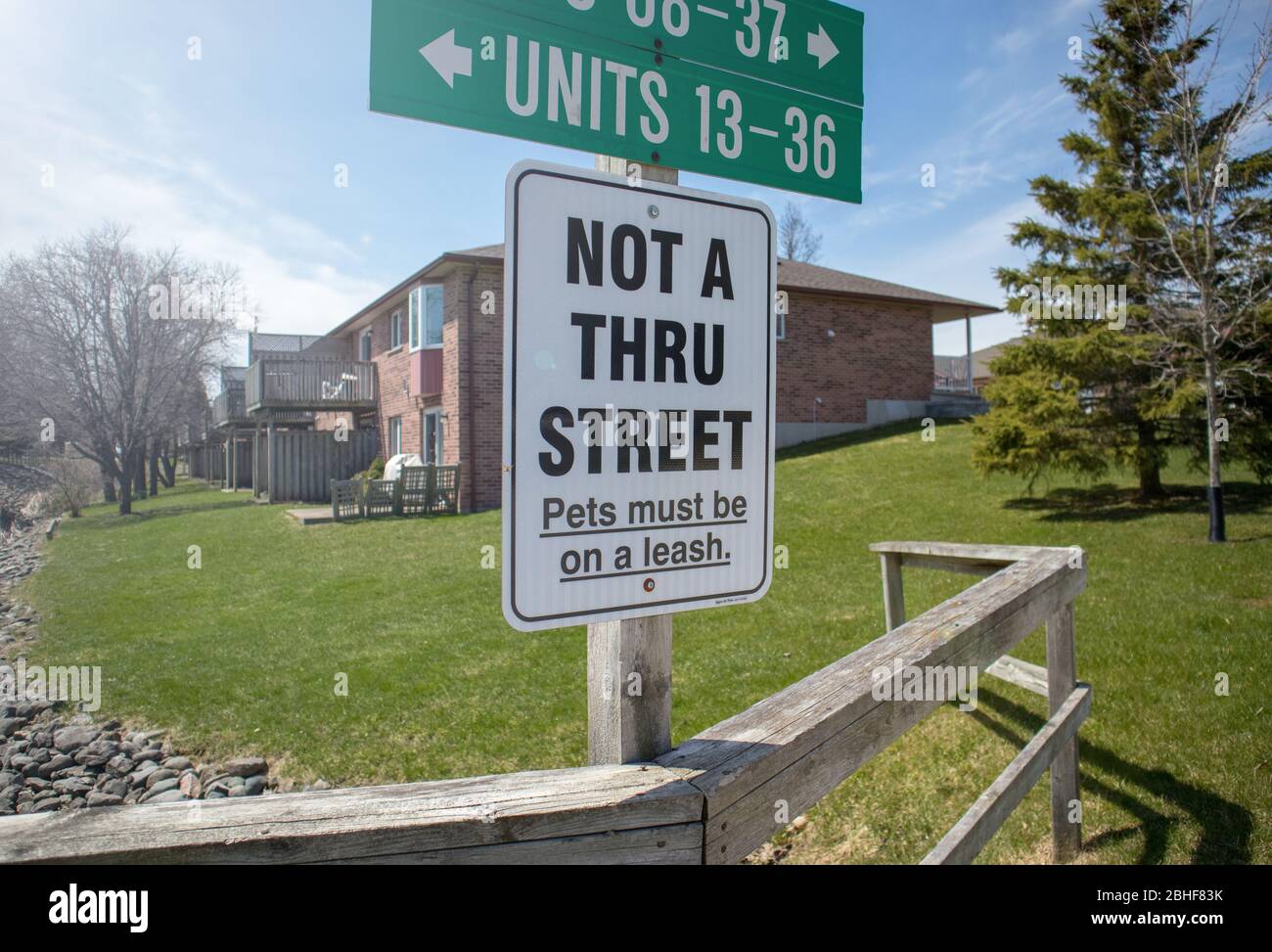 I cartelli ci dicono indicazioni e indirizzi, il modo non è 'attraverso strada', i cani devono essere sul guinzaglio. Il complesso è residenziale e tranquillo. Foto Stock