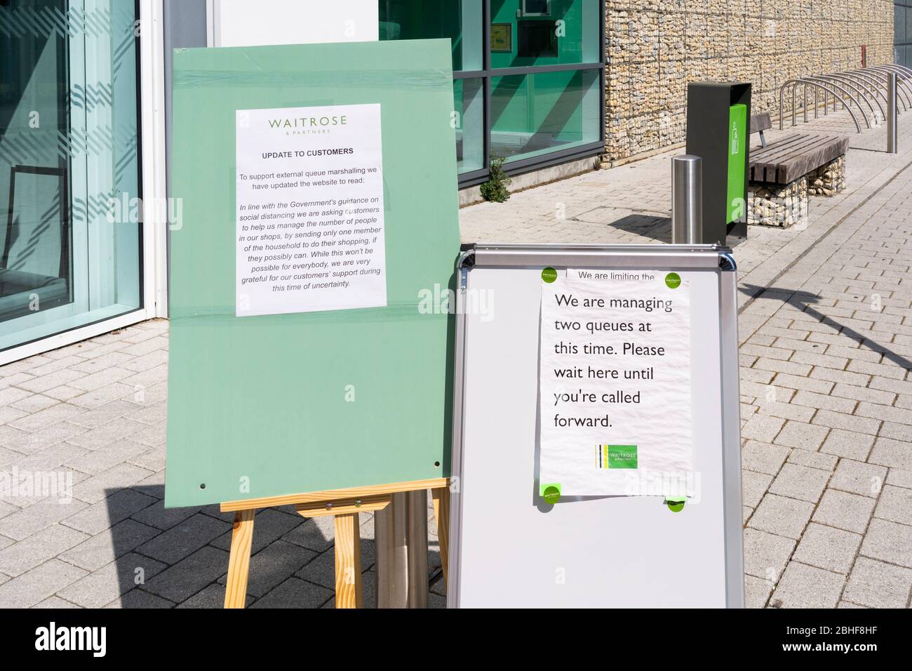 Consulenza su bacheche fuori dal supermercato Waitrose che consiglia ai clienti di fare la coda in base alle indicazioni governative sulle distanze sociali dovute a Covid 19, Regno Unito Foto Stock