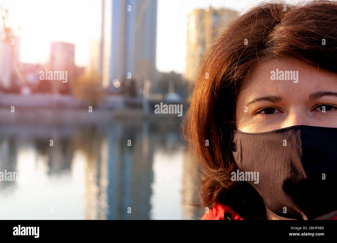 Ritratto di una donna con maschera nera fatta a mano. Quarantena nel 2020. Prevenzione dell'epidemia di coronavirus SARS-cov-2. Foto Stock