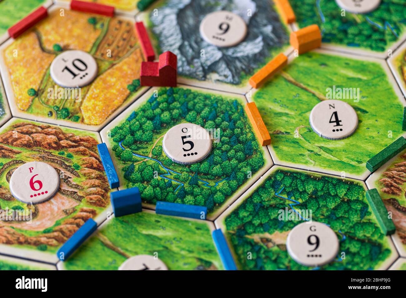 Coloni di Catan, un popolare gioco da tavolo. I giocatori stanno rimescolando la zona per ottenere più risorse e punti vittoria. Foto Stock