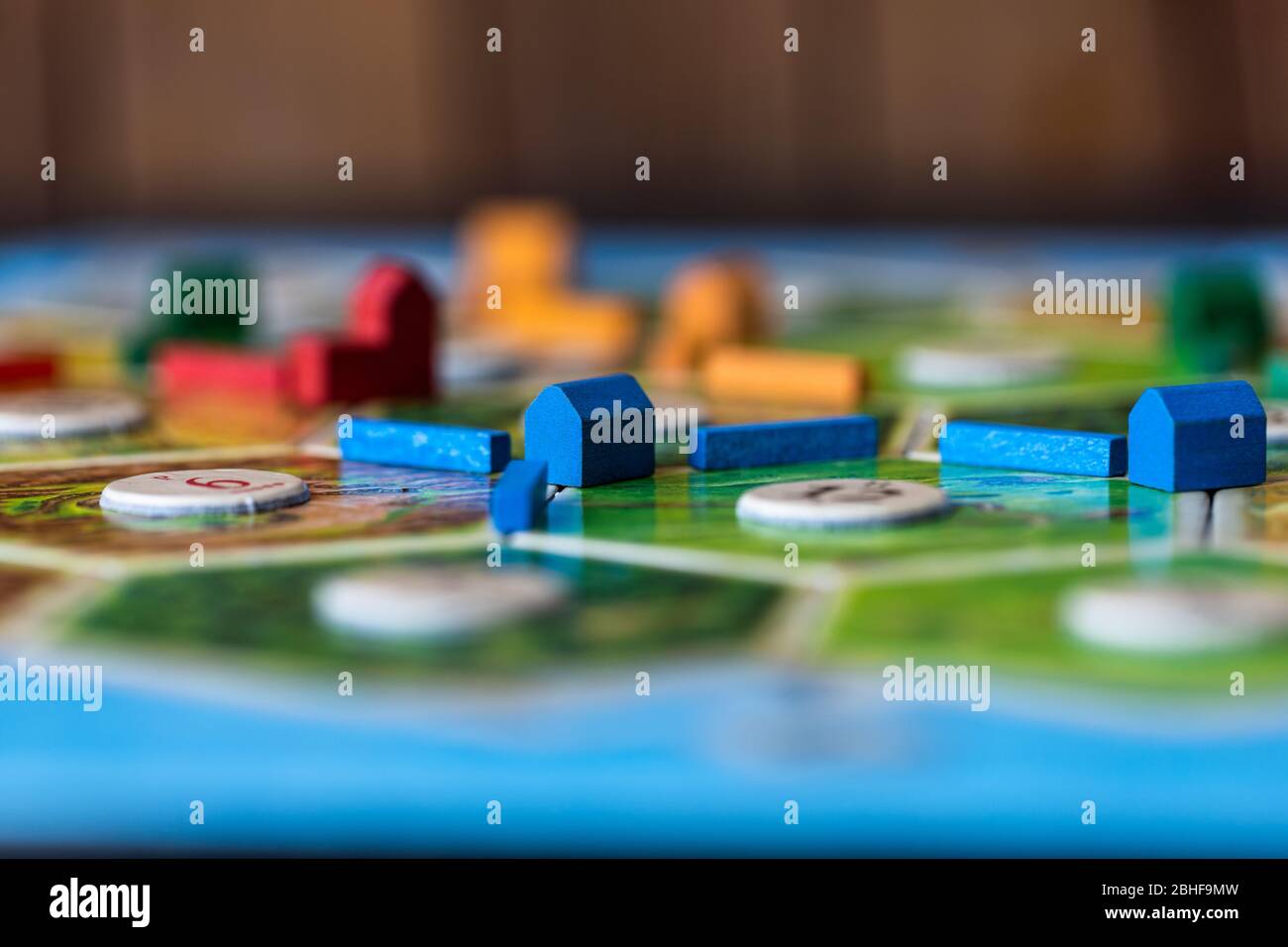 Coloni di Catan, un popolare gioco da tavolo. I giocatori stanno rimescolando la zona per ottenere più risorse e punti vittoria. Foto Stock