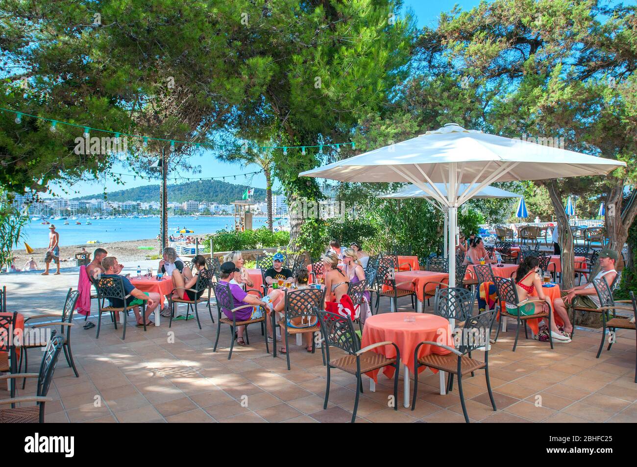 Giovani vacanzieri che si rilassano al s'Arenal Beach Cafe, San Antonio, Ibiza, Baleari, Spagna Foto Stock