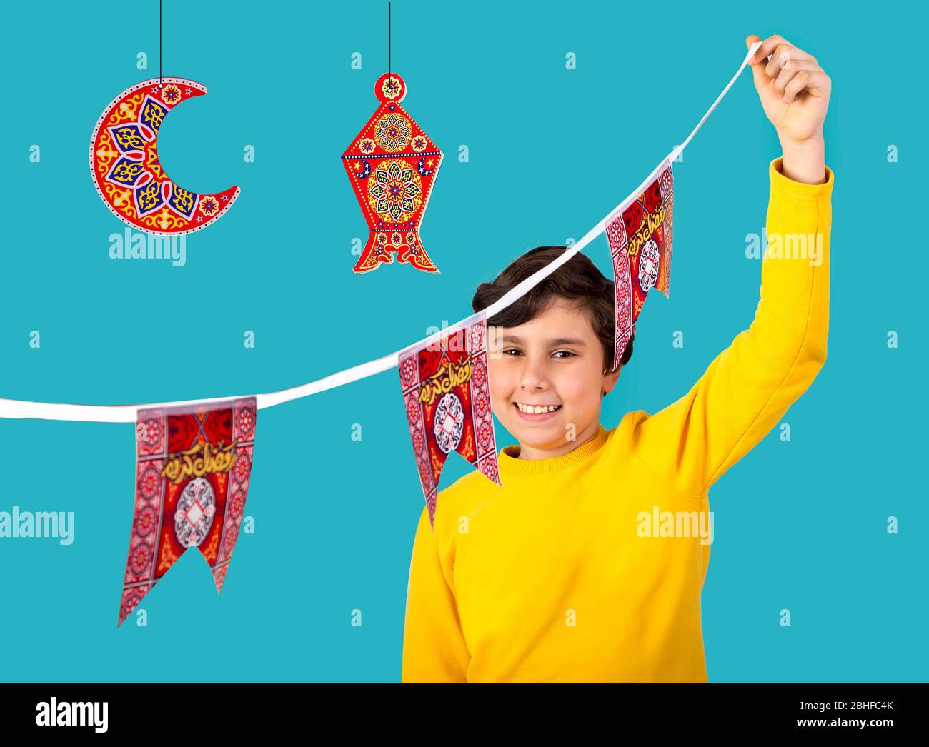 Musulmani Kid preparare decorazioni per celebrare il festival Ramadan -  lanterna , mezzaluna e carta forme islamiche con parola Ramadan Kareem -  traduzione Foto stock - Alamy