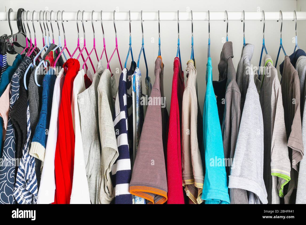 Abbigliamento da uomo e da donna su staffe in silicone nell'armadio. Le stesse spalle. Organizzazione di storage. Ordine e pulizia. Quarantena, se Foto Stock