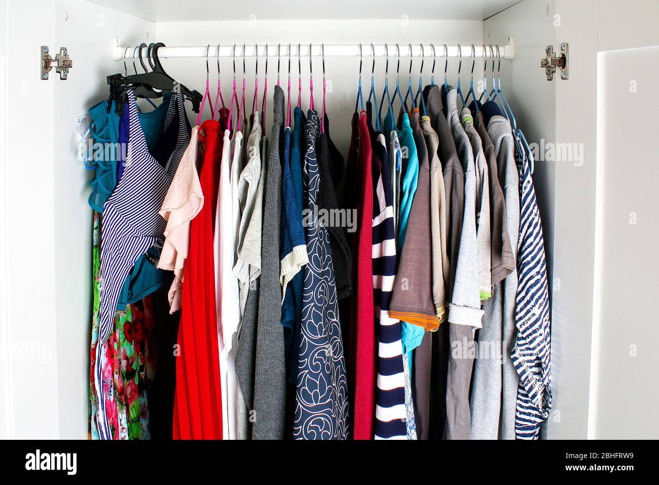 Abbigliamento da uomo e da donna su staffe in silicone nell'armadio. Le stesse spalle. Organizzazione di storage. Ordine e pulizia. Quarantena, se Foto Stock