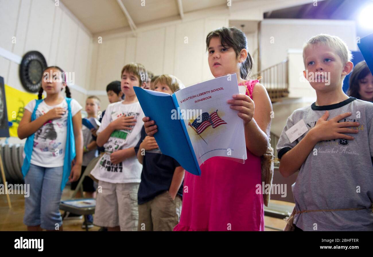 Georgetown Texas USA, agosto 17 2012: Gli studenti cantano la Star Spangled Banner durante una settimana 'Vacation Liberty School' che insegna ai bambini di età compresa tra 7-12 e 7 anni 'i benefici della libertà dal punto di vista della fede, Speranza e carità, le idee che gli organizzatori dicono sono state foste foste dei padri fondatori dell'America quando hanno creato la Dichiarazione di indipendenza, la carta dei diritti e la Costituzione per una società giudaica-cristiana. Pur essendo un programma non politico, esso sostiene gli ideali simili al Tea Party di responsabilità fiscale, mercati liberi e governo limitato. ©Bob Daemmrich Foto Stock