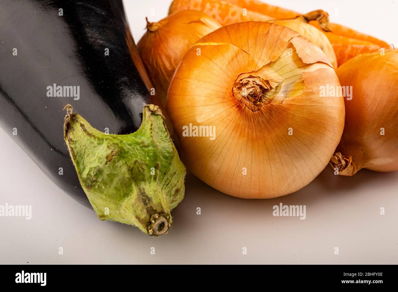 Cipolle succose e melanzane mature su sfondo bianco. Primo piano Foto Stock