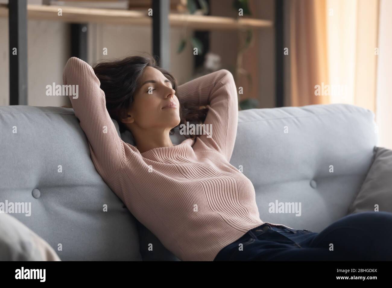 Spensierato giovane bella casalinga napping sul divano. Foto Stock