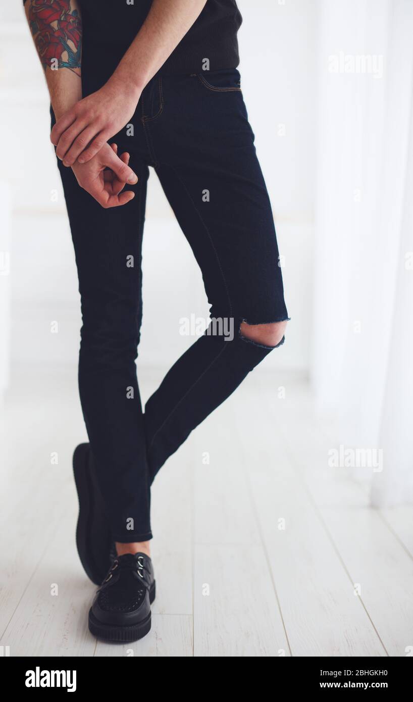 gambe sottili di giovane uomo con jeans strappati e scarpe in pelle Foto  stock - Alamy